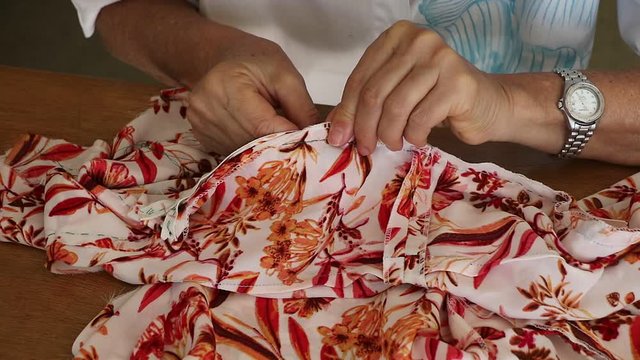 Artes&atilde; costureira alinhavando um ziper para depois ser costurado.