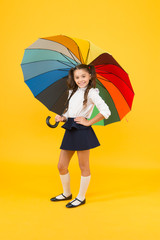 Accessory making walk to school through the rain safer. Small child holding colorful umbrella rain accessory. Little girl with fashion accessory for rainy weather. The coolest accessory on the street