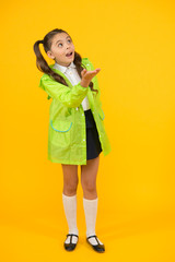 Schoolgirl in green cloak. Waterproof accessory. Kid girl happy wear waterproof cloak. Enjoy fall weather with proper garments. Waterproof accessories make rainy fall day cheerful and pleasant
