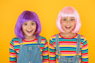 Cheerful friends in bright colorful wigs. Anime cosplay party concept. Happy childhood concept. Anime culture influence. Invitation for anime party. Happy little girls smiling faces. Anime fan