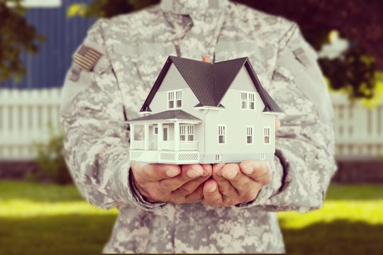 Miniature house in soldier hands