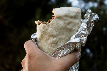 Holding a Burrito with a Bite Out of It in California