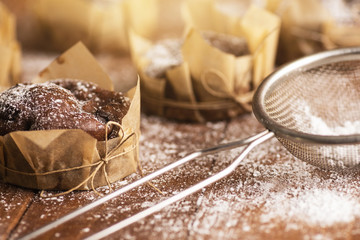 Tasty chocolate muffins in powdered sugar