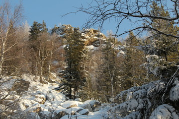 Fototapeta na wymiar Stone mountains in a snow-covered forest 2.