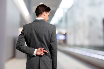Businessman with his fingers crossed behind his back - concept for good luck or dishones