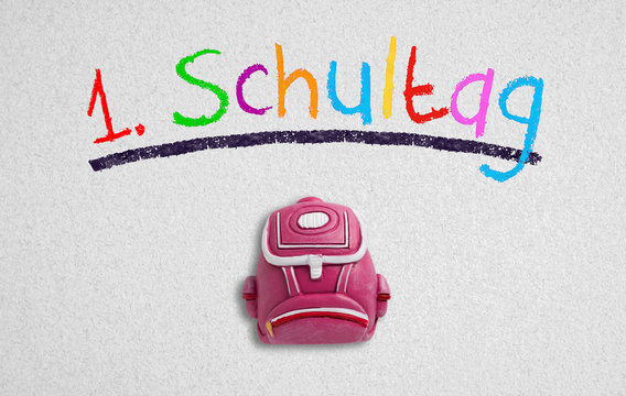 German message "first day of school" on paper background 