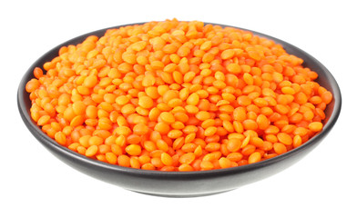 Pile lentil in black bowl isolated on white background