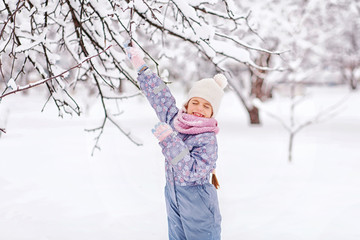 cheerful girl having fun at winter snow forest outdoor