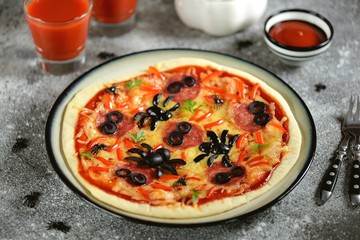 Cute pizza with olives and sausage spider for Halloween party. Children's food. 