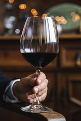 Male hand with a glass of red wine