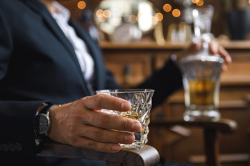 Male hand with a glass of expensive whiskey