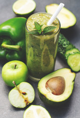 Green smoothie of apple, cucumber, avocado and pepper in a glass