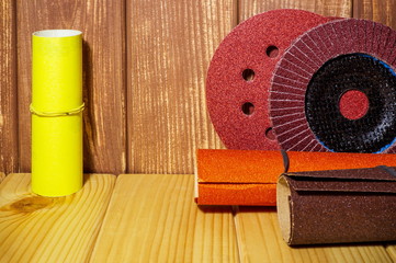 Set of abrasive tools and sandpaper on brown vintage wood background