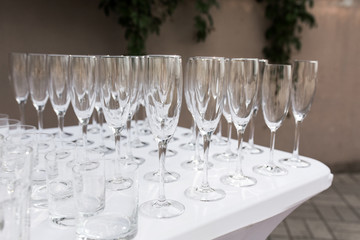 Many empty clean glasses for guests at the buffet festive wedding table