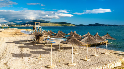 Straw umbrellas on a beach in Saranda, Albania