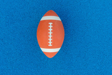 Ball for American Football on blue court, outdoor. American Football ball on a blue multifunctional sport outdoor court