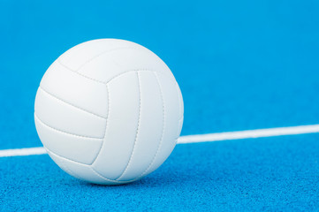 Volleyball ball on blue playground with white line