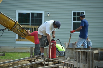 Naklejka na ściany i meble construction workers pouring a foundation