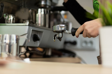 Fototapeta na wymiar Barista girl is preparing aromatic coffee with a coffee machine. Barista work in a coffee shop
