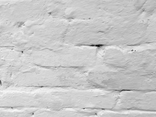 Brick red old wall covered with white paint. Bricks pattern. Close-up.