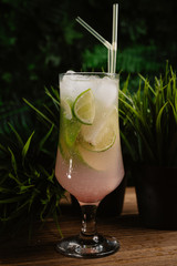 refreshing summer cocktail with lime, green and ice on a green summer background. mahito in a glass