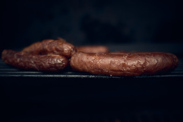 Grilled chorizo sausage over the barbecue fire. You can see the smoke, the fire and the heat as well as the fiery ones of the melted fats when falling under the direct fire