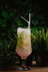 refreshing summer cocktail with lime, green and ice on a green summer background. mahito in a glass