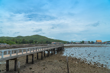 Fototapeta na wymiar The Samae San Pier Bridge is long and connects to the pier to Samae San Island. .You can walk to see coral reefs and fish in the tide..