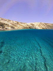 Fototapeta na wymiar Above and below underwater photo of crystal clear sea paradise rocky seascape of Laki beach in Kato Koufonisi island, Cyclades, Greece