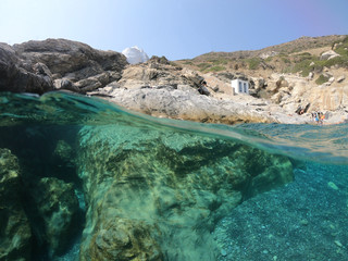 Above and below underwater photo of crystal clear sea paradise rocky seascape and small chapel of...