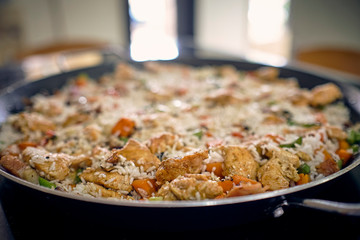 preparation of rice with chicken in Latin style with vegetables, broccoli, peas, carrots, white rice