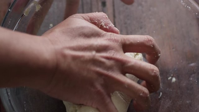 Slow motion close up, kneading flour dough in mixing bowl