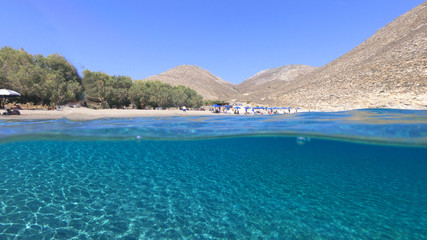 Above and below underwater photo of crystal clear turquoise beach of Kaminakia, Astypalaia island, Dodecanese, Greece