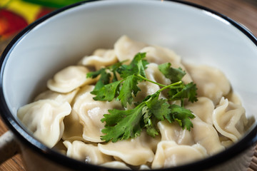 Pelmeni, traditional Russian dumpling dish with meat on table - selective focus, top down photo 