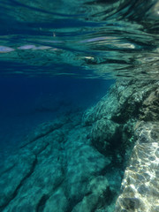 Fototapeta na wymiar Above and below underwater photo of crystal clear sea paradise rocky seascape of Laki beach in Kato Koufonisi island, Cyclades, Greece