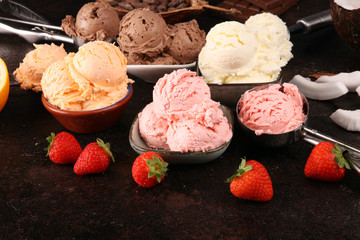 Set of ice cream scoops of different colors and flavours with berries, chocolate and fruits on background