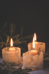 New Year's background. Christmas burning candles with fir tree in the snow