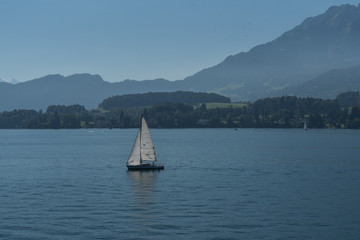 Yacht on a mountain lake in the background of mountains. Beautiful landscape