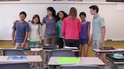 Teacher and junior high students posing in classroom