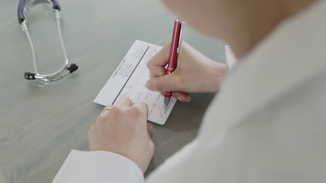 Caucasian doctor writing a prescription