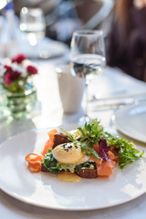 Poached egg with smoked salmon on rye bread. Brunch in restaurant
