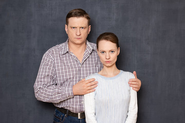 Portrait of serious couple looking strictly at camera