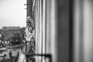 Sexy girl in a white robe standing on the balcony