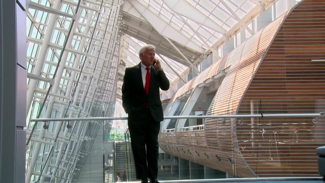 Caucasian businessman talking on cell phone in atrium