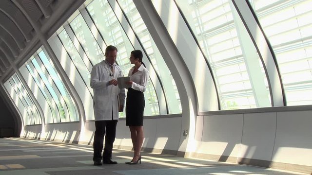 Caucasian doctor and administrator discussing tablet and x-ray