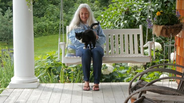 Caucasian woman petting cat on patio