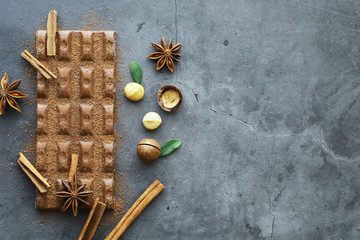 A bar of milk chocolate on the table. Chocolate with nuts and cinnamon.