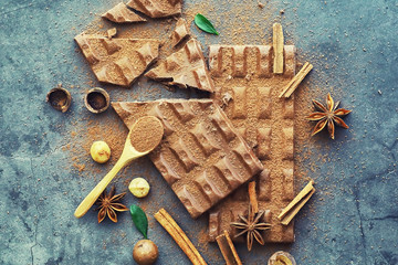 A bar of milk chocolate on the table. Chocolate with nuts and cinnamon.