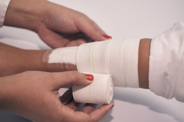 a woman's arm is bandaged with a white bandage and a first aid aid