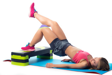 Woman doing exercises for legs lying on the mat